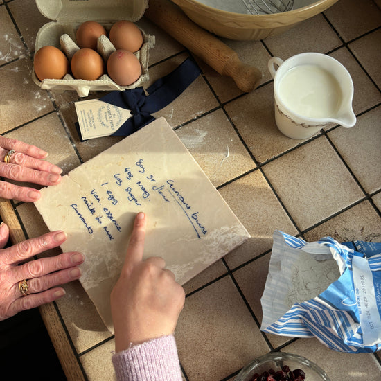 Baking ingredients and recipe keepsake platter on a tiled kitchen counter