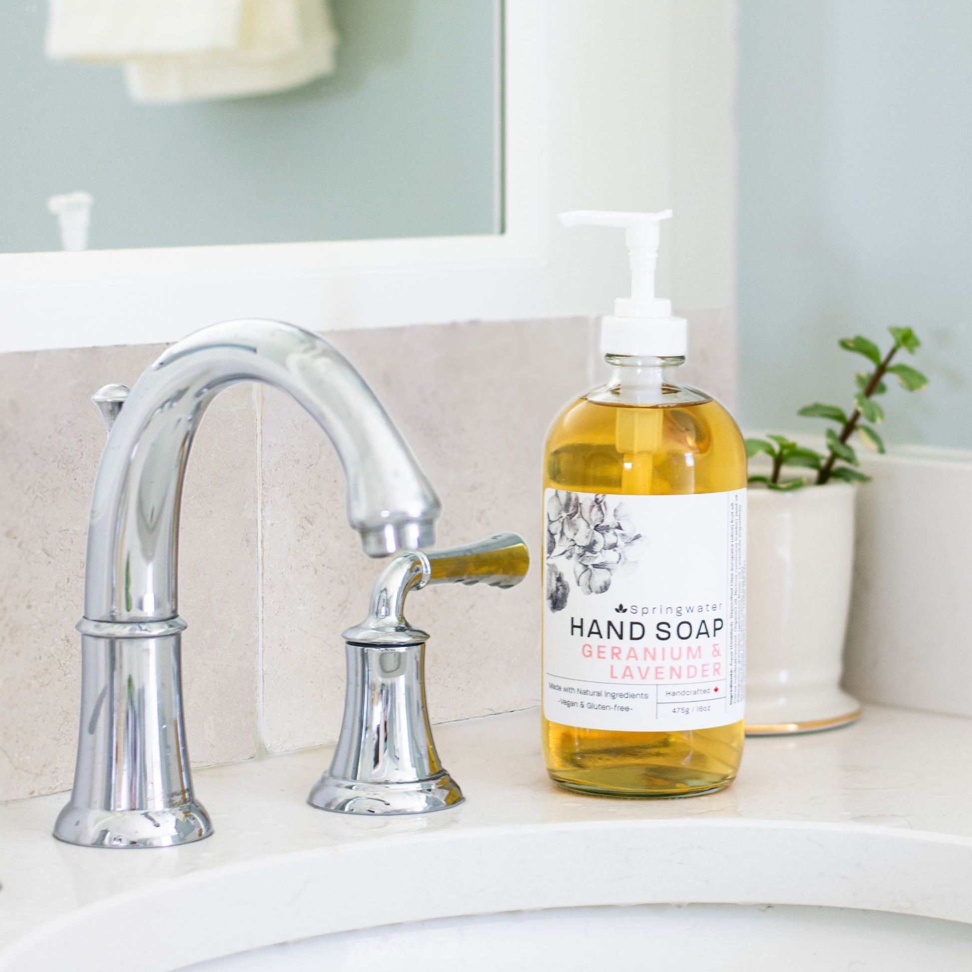 A tiled splashback behind a bathroom sink. The splashback is made up of medium plain cream marble tiles.