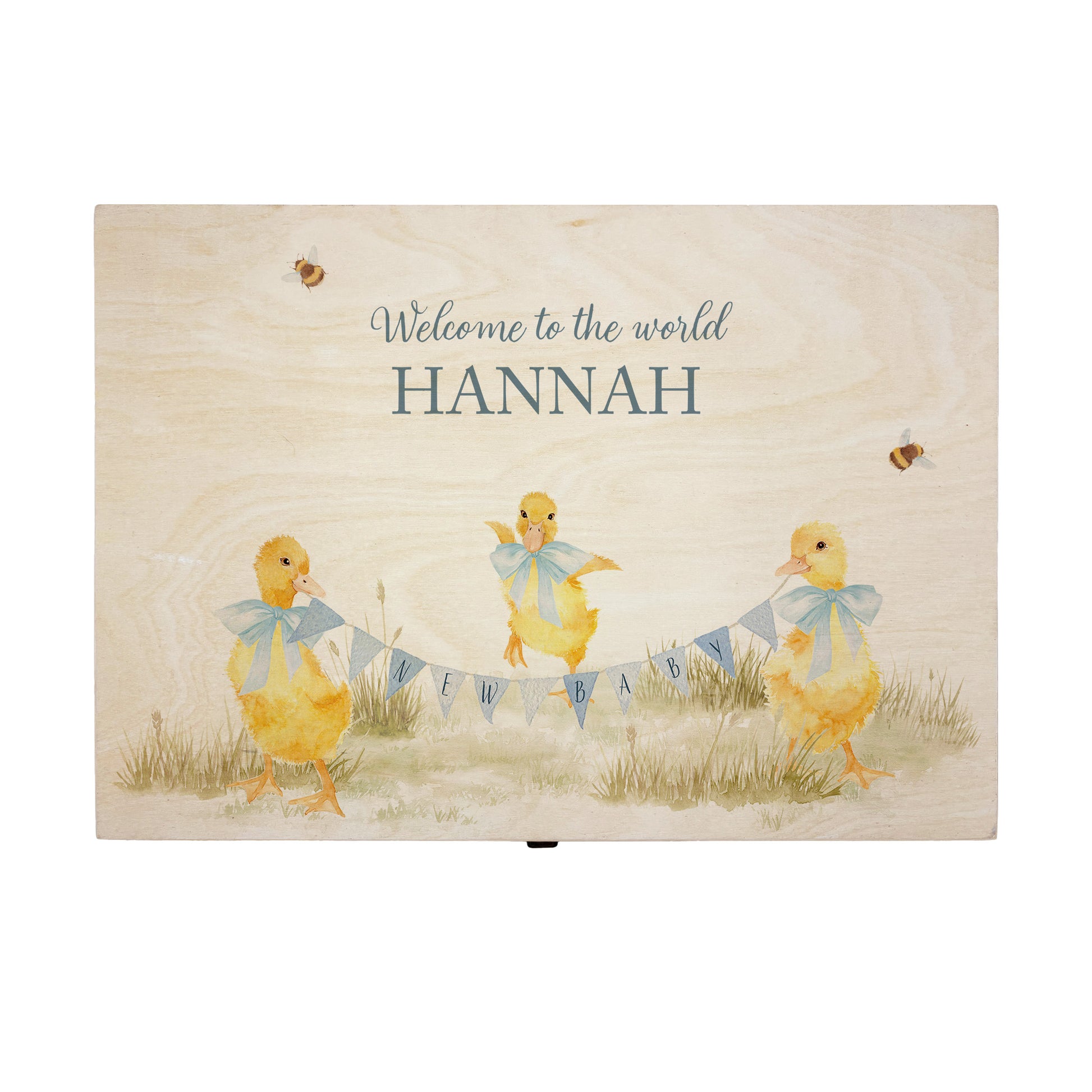 Large sized wooden pine personalised keepsake box. The design theme is perfect for New babies, Welcome to the world, baby showers and christenings. This design has baby ducklings  in meadow style grass and a buzzy Bee flying around. This design can be personalised by adding a beautiful bunting and a luxurious bow around their necks in blue or pink. Add the extra special touch to your special occasion.