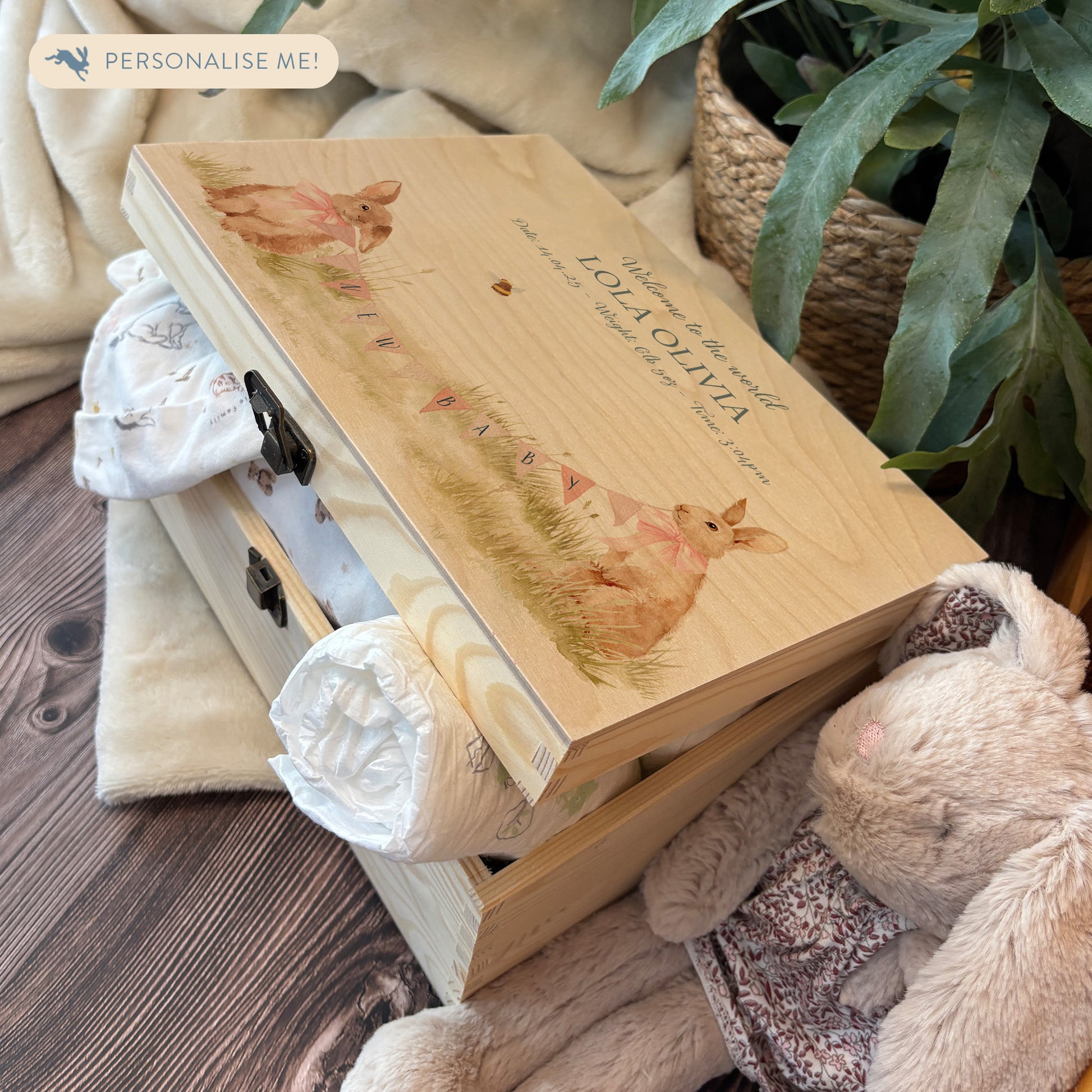 Medium sized wooden pine personalised keepsake box. The design theme is perfect for New babies, Welcome to the world, baby showers and christenings. The picture also shows an example in a nursey room filled with nappies, vests and teddys.