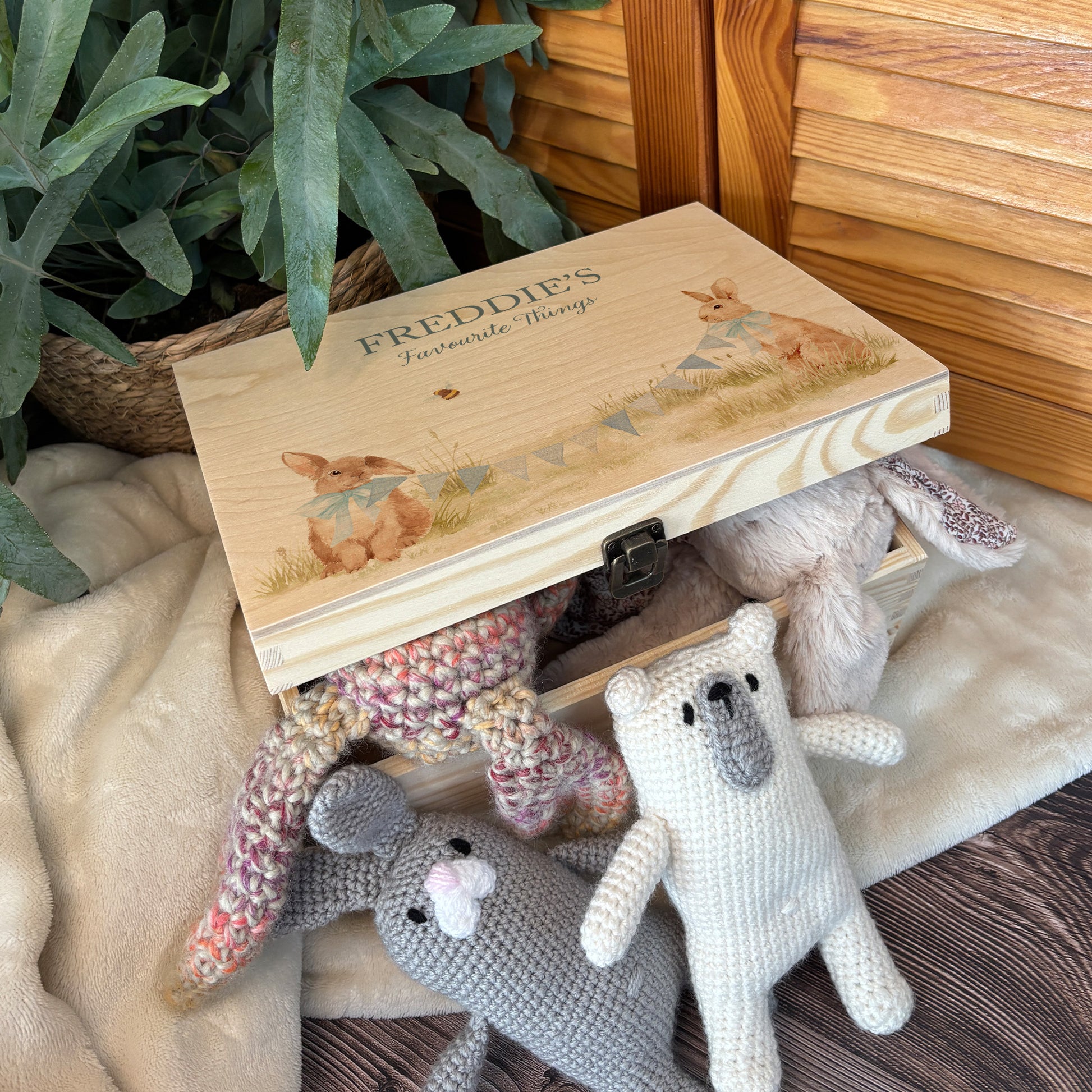 Medium sized wooden pine personalised keepsake box. The design theme is perfect for New babies, Welcome to the world, baby showers and christenings. The picture also shows an example in a nursey room filled with nappies, vests and teddys.