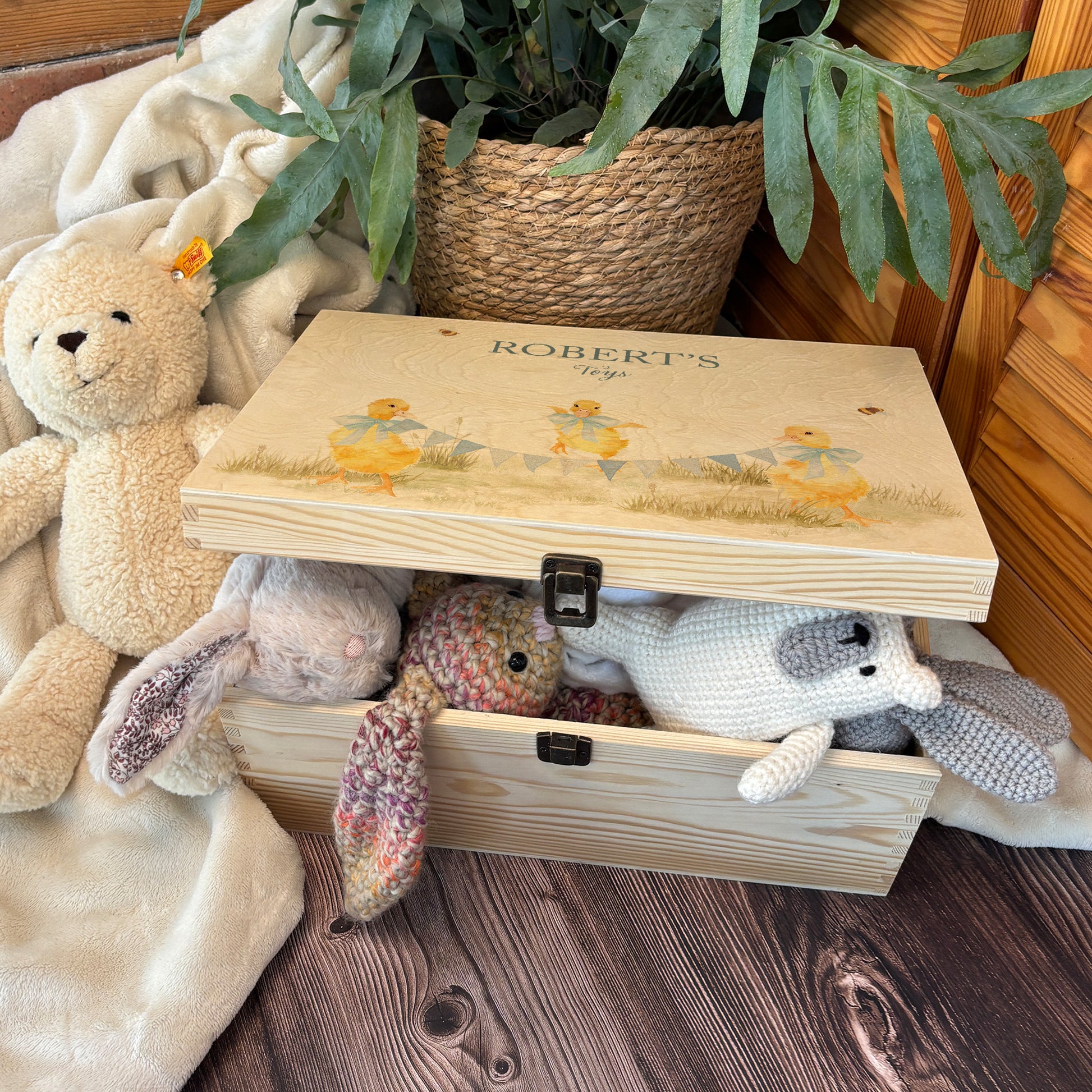 Large sized wooden pine personalised keepsake box. The design theme is perfect for New babies, Welcome to the world, baby showers and christenings. The picture also shows an example in a nursey room filled with nappies, vests and teddys.