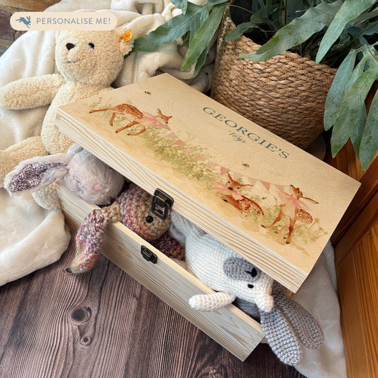 Large sized wooden pine personalised keepsake box. The design theme is perfect for New babies, Welcome to the world, baby showers and christenings. This design has baby Fawns/Deer  in meadow style grass and a buzzy Bee flying around. The picture also shows an example in a nursey room filled with nappies, vests and teddys.
