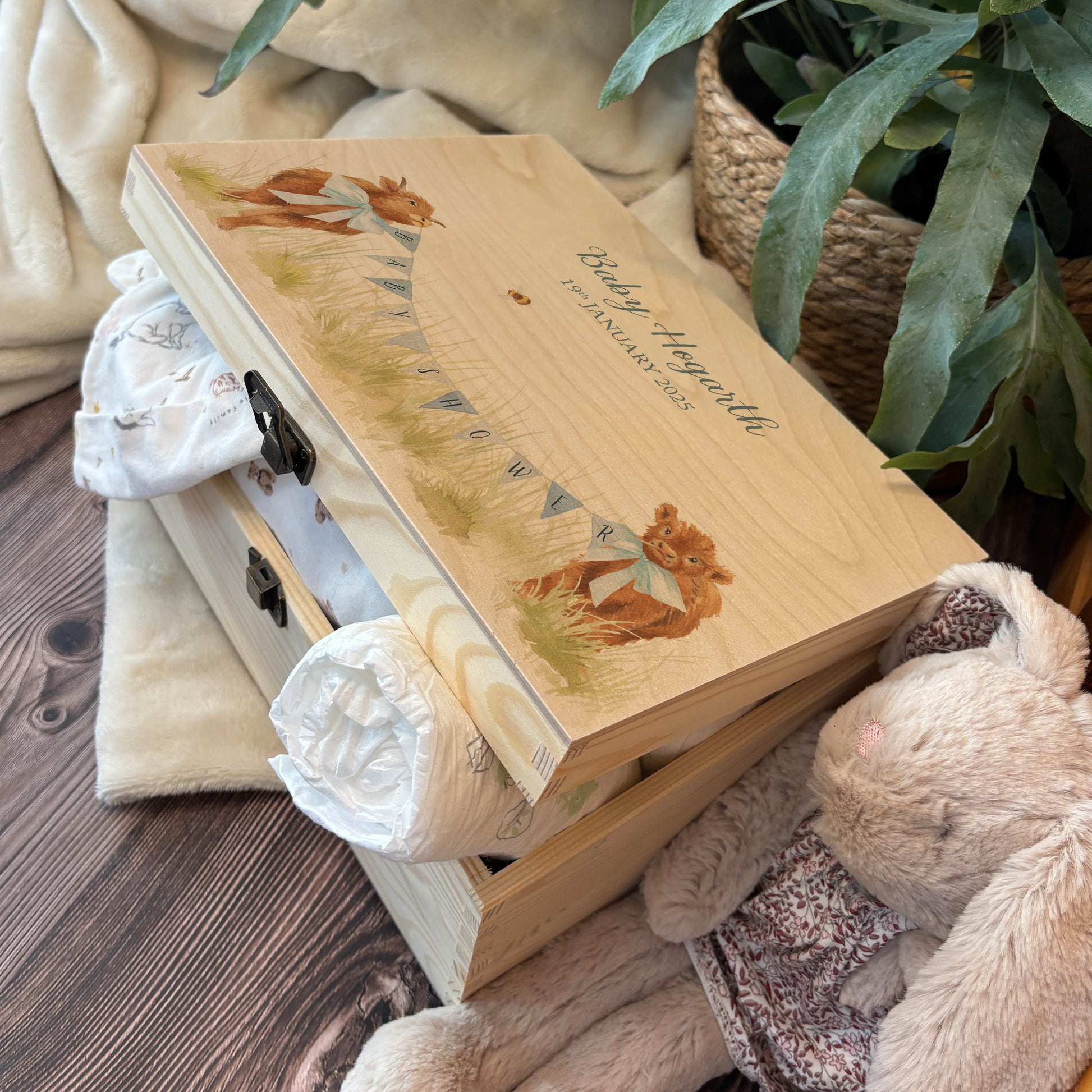 Medium sized wooden pine personalised keepsake box. The design theme is perfect for New babies, Welcome to the world, baby showers and christenings. The picture also shows an example in a nursey room filled with nappies, vests and teddys.