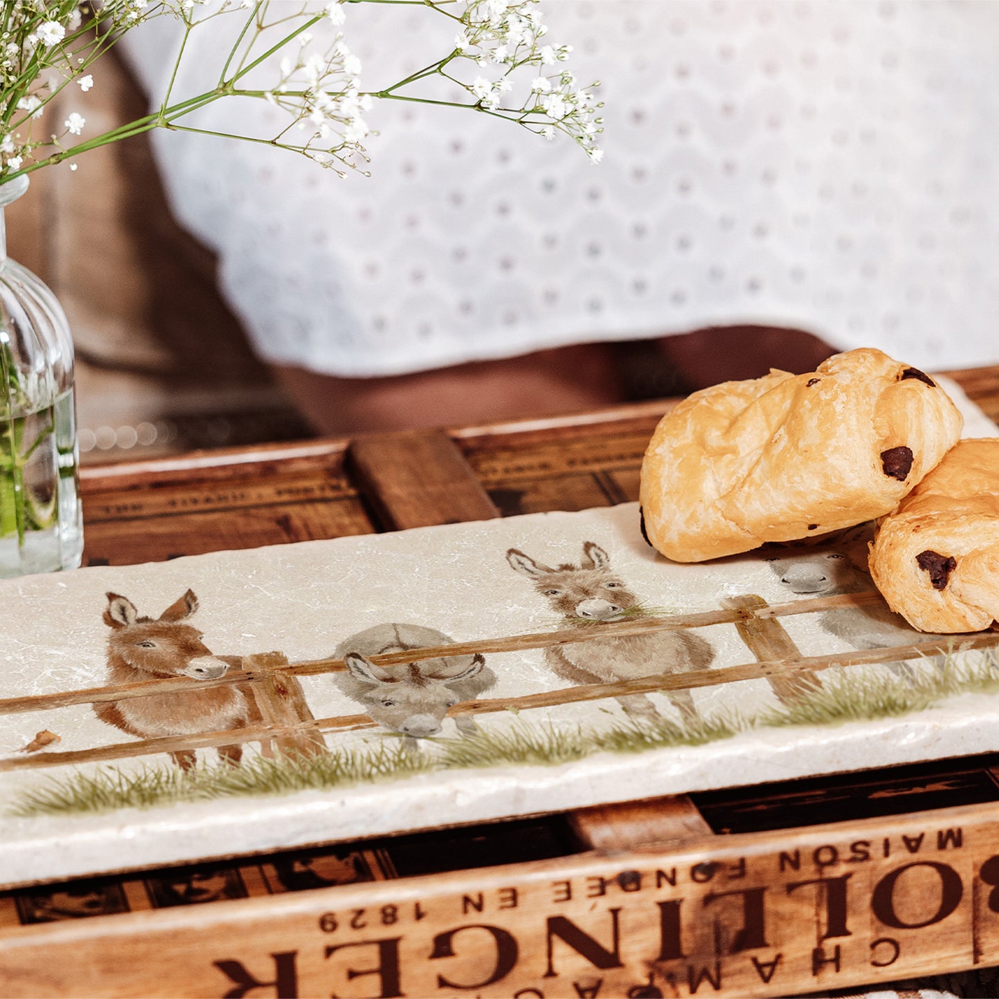 A rectangular marble sharing platter set on a coffee table to serve pastries.