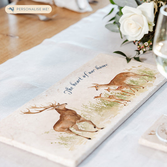 A personalised marble sharing platter featuring a stag, doe and two fawns, with the phrase 'The heart of our home' in dark blue brush script text.