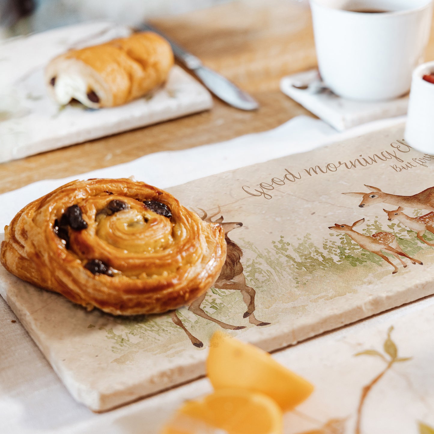 A personalised marble sharing platter reading 'good morning' set on a breakfast table to serve pastries.