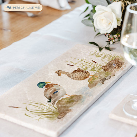 A handmade marble sharing platter with a mallard duck watercolour design. The platter is set in the middle of a dining table as a beautiful centrepiece.