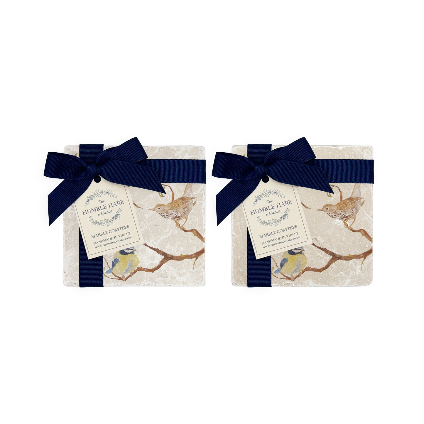 A set of 4 handmade marble coasters packaged in 2 pairs, with a luxurious dark blue bow and gift tag.