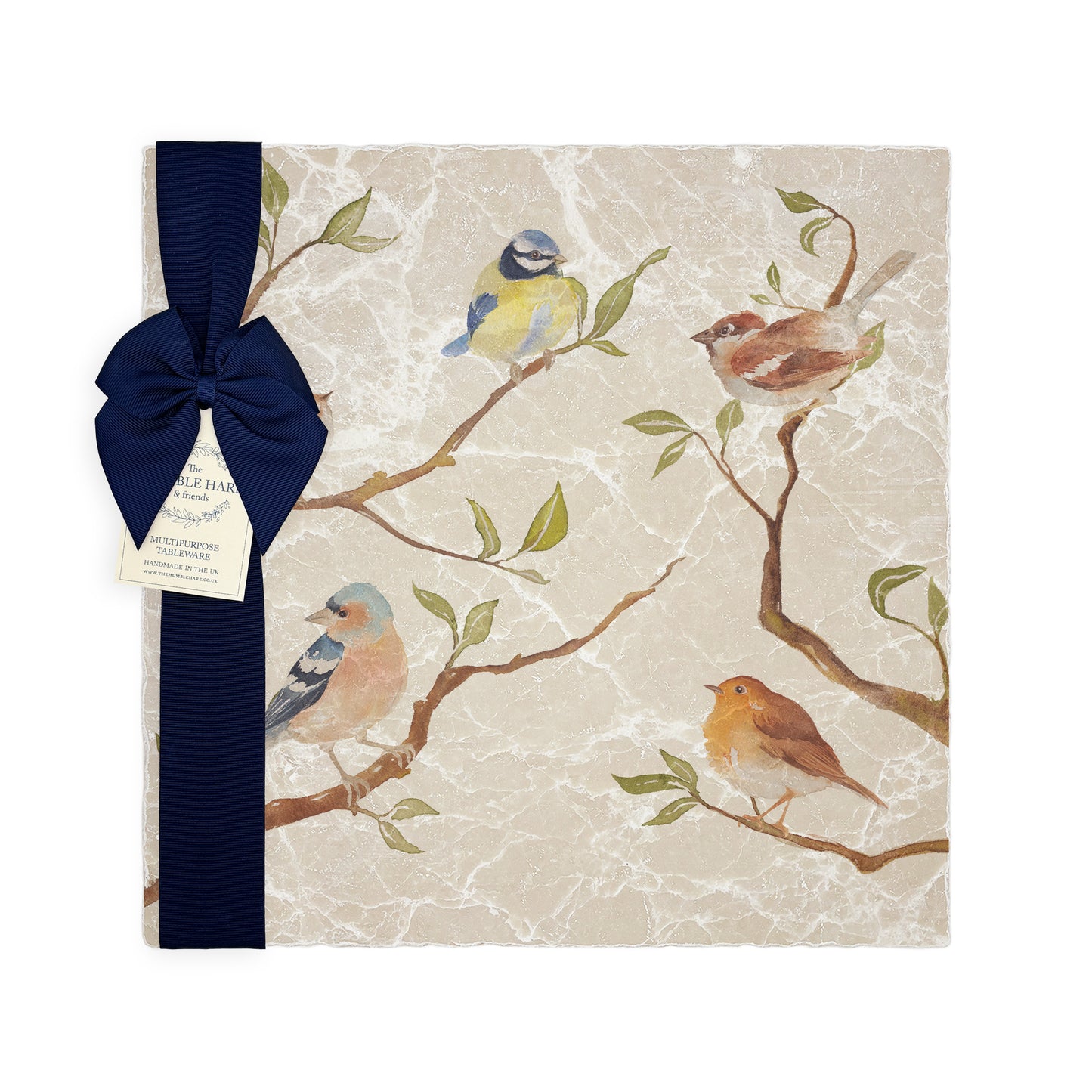 A multipurpose marble platter with a British garden birds on branches design, packaged with a luxurious dark blue bow and branded gift tag.
