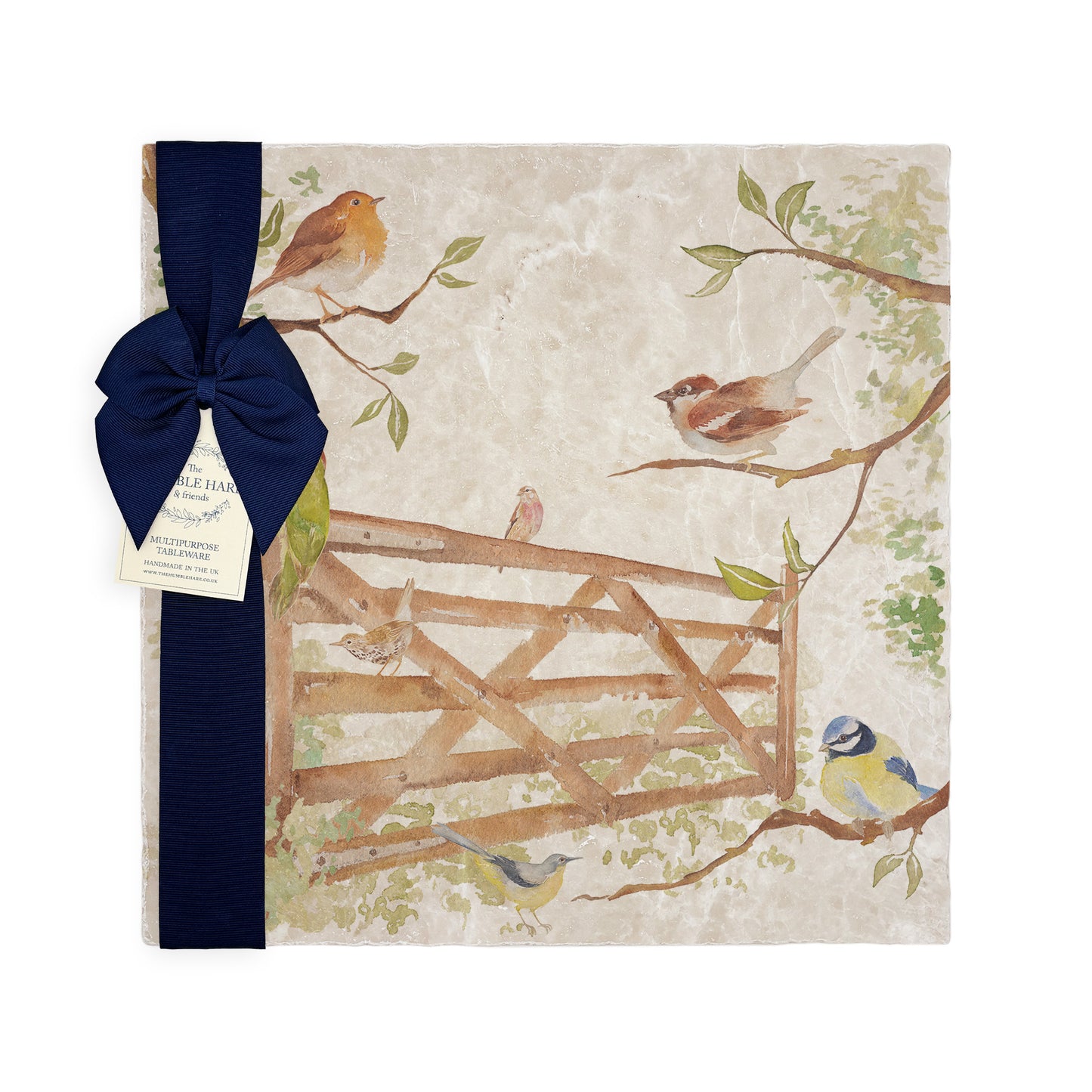A multipurpose marble platter with a design featuring British garden birds in the hedgerow around the paddock gate, packaged with a luxurious dark blue bow and branded gift tag.