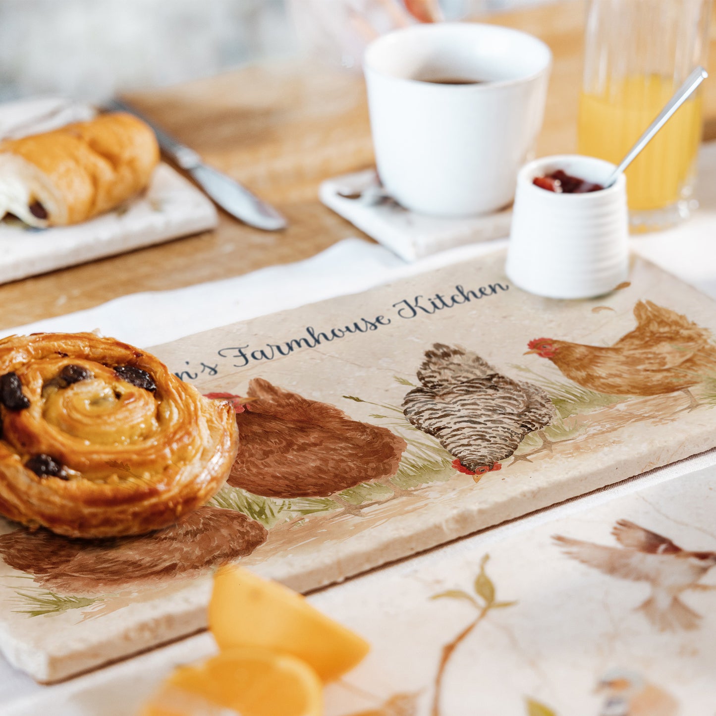 A handmade personalised marble sharing platter set on a table to serve breakfast. The bespoke blue test reads 'Farmhouse Kitchen'.
