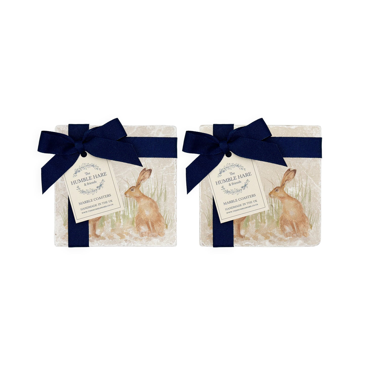 A set of 4 handmade marble coasters packaged in 2 pairs, with a luxurious dark blue bow and gift tag.
