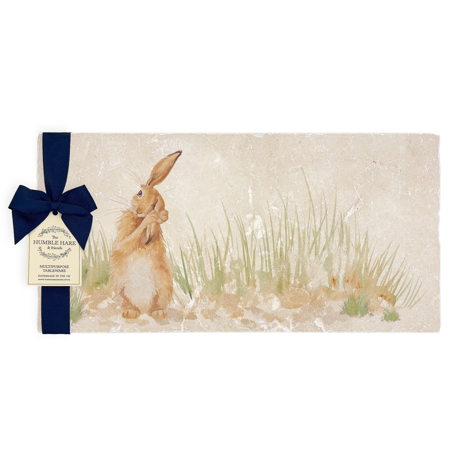 A multipurpose marble platter with a watercolour design featuring a hare washing his ear, packaged with a luxurious dark blue bow and branded gift tag.