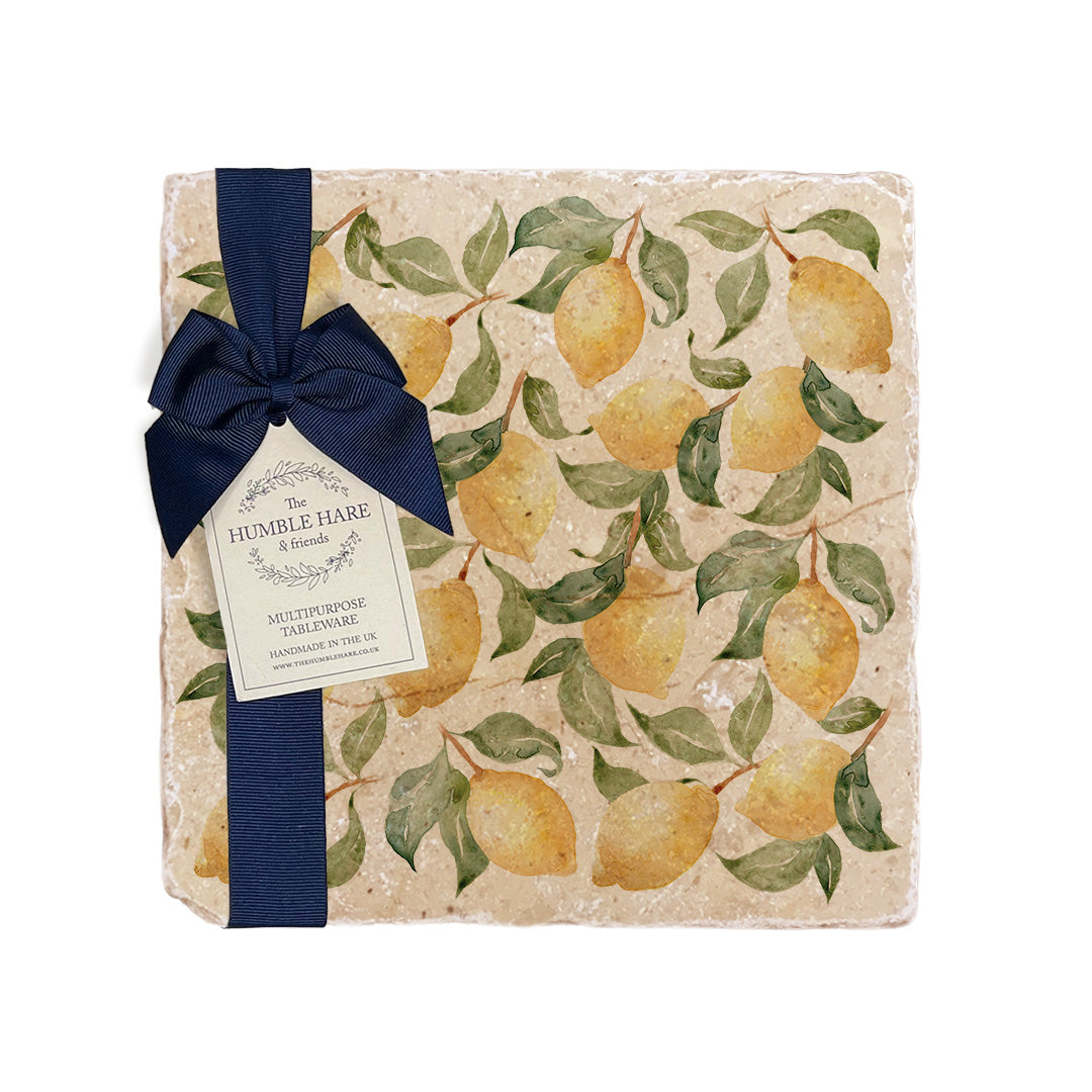 A medium multipurpose marble platter with a watercolour lemon pattern, packaged with a luxurious dark blue bow and branded gift tag.