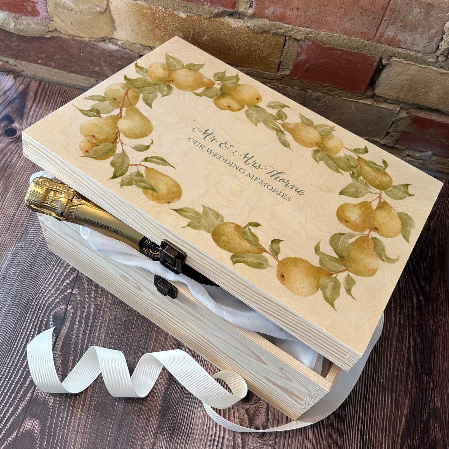 Large Pear wreath Personalised wedding keepsake box with vibrant watercolour fruit design, featuring the couple’s names and wedding date on natural pine wood. This box can be customised and is a truly unique wedding & Anniversary gift. Example shown of how you can fill your special box with gifts for the Bride and Groom