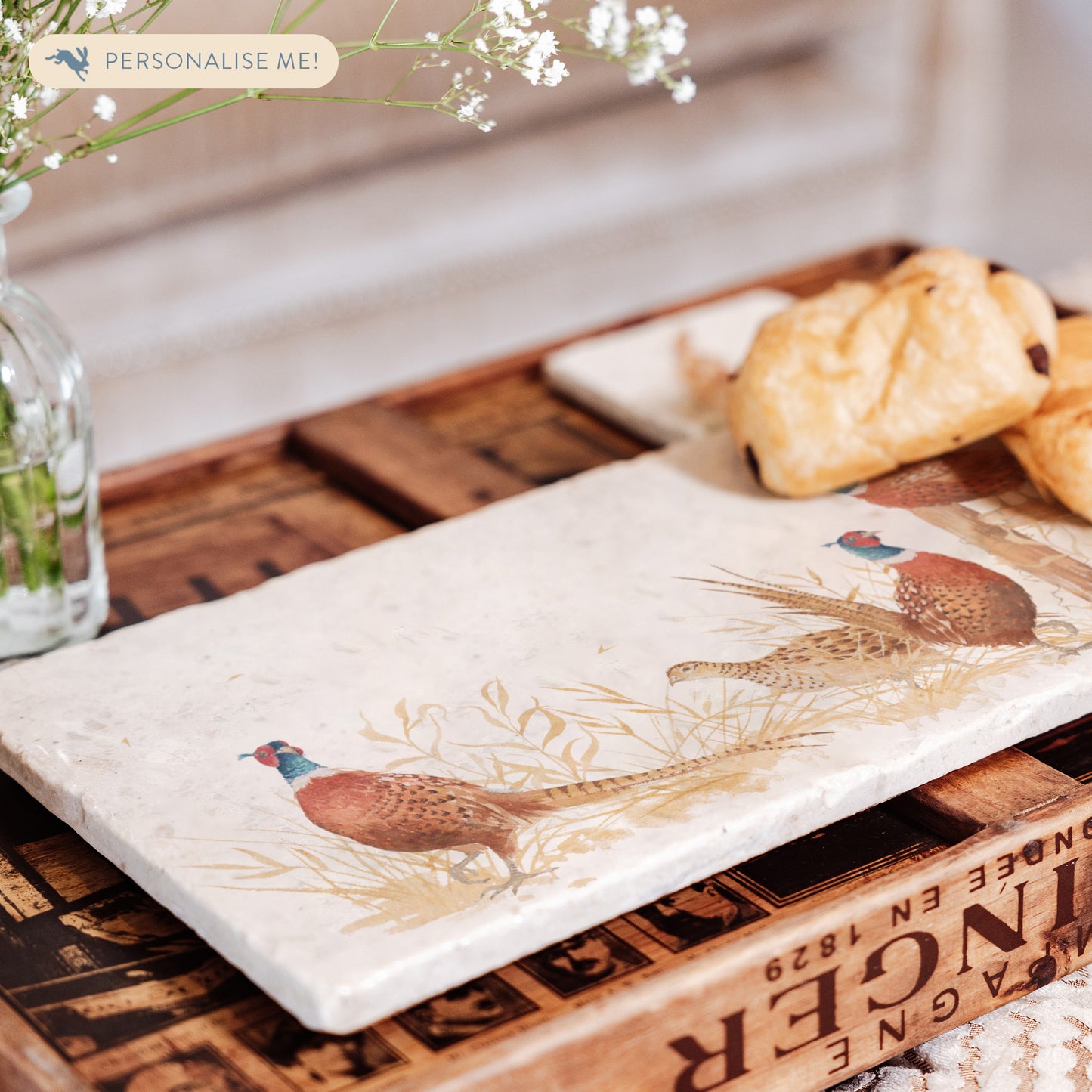 A rectangular cream marble sharing platter, featuring a watercolour design of four pheasants around a countryside fence post in golden grass.