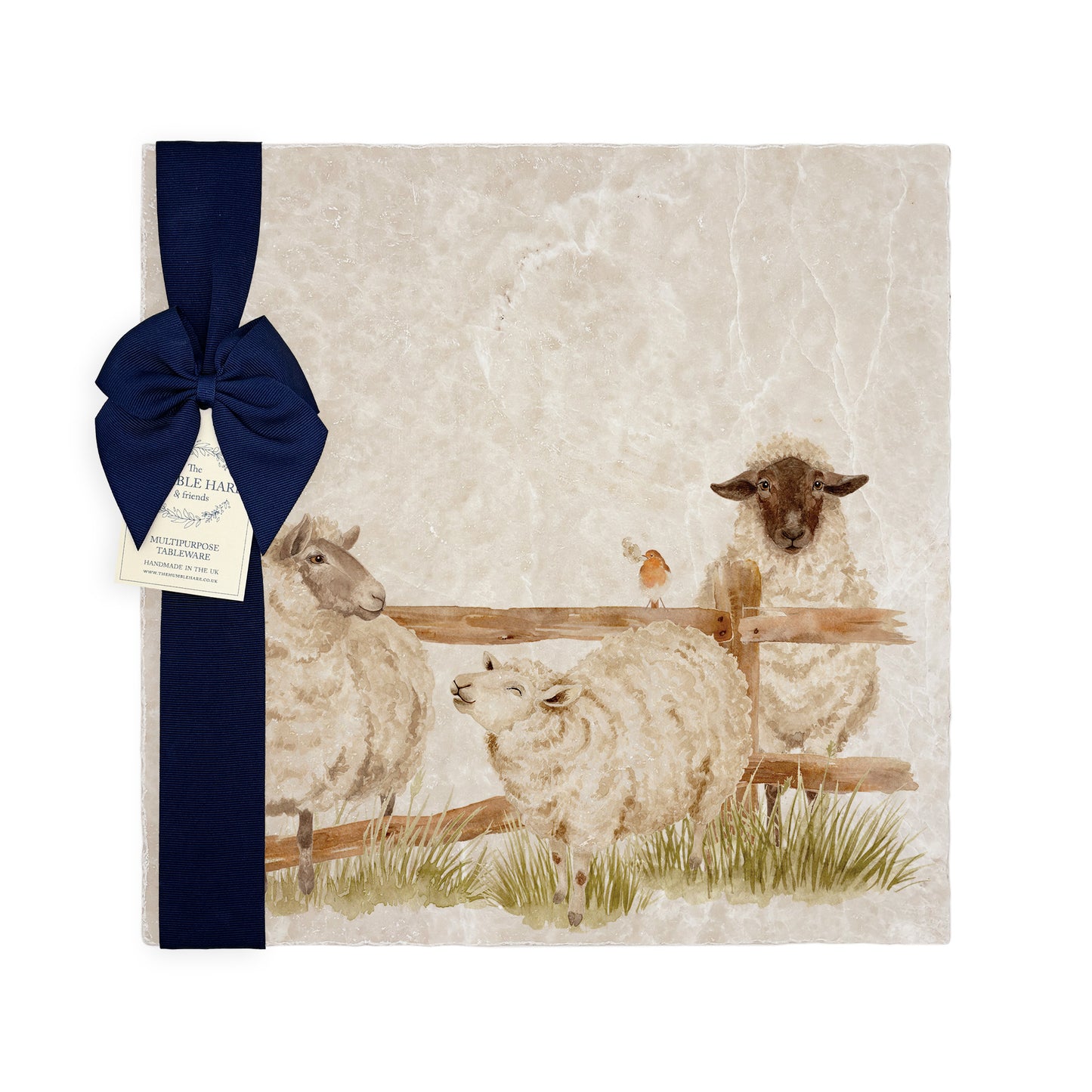 A large multipurpose marble platter with a watercolour design of sheep escaping their field, packaged with a luxurious dark blue bow and branded gift tag.