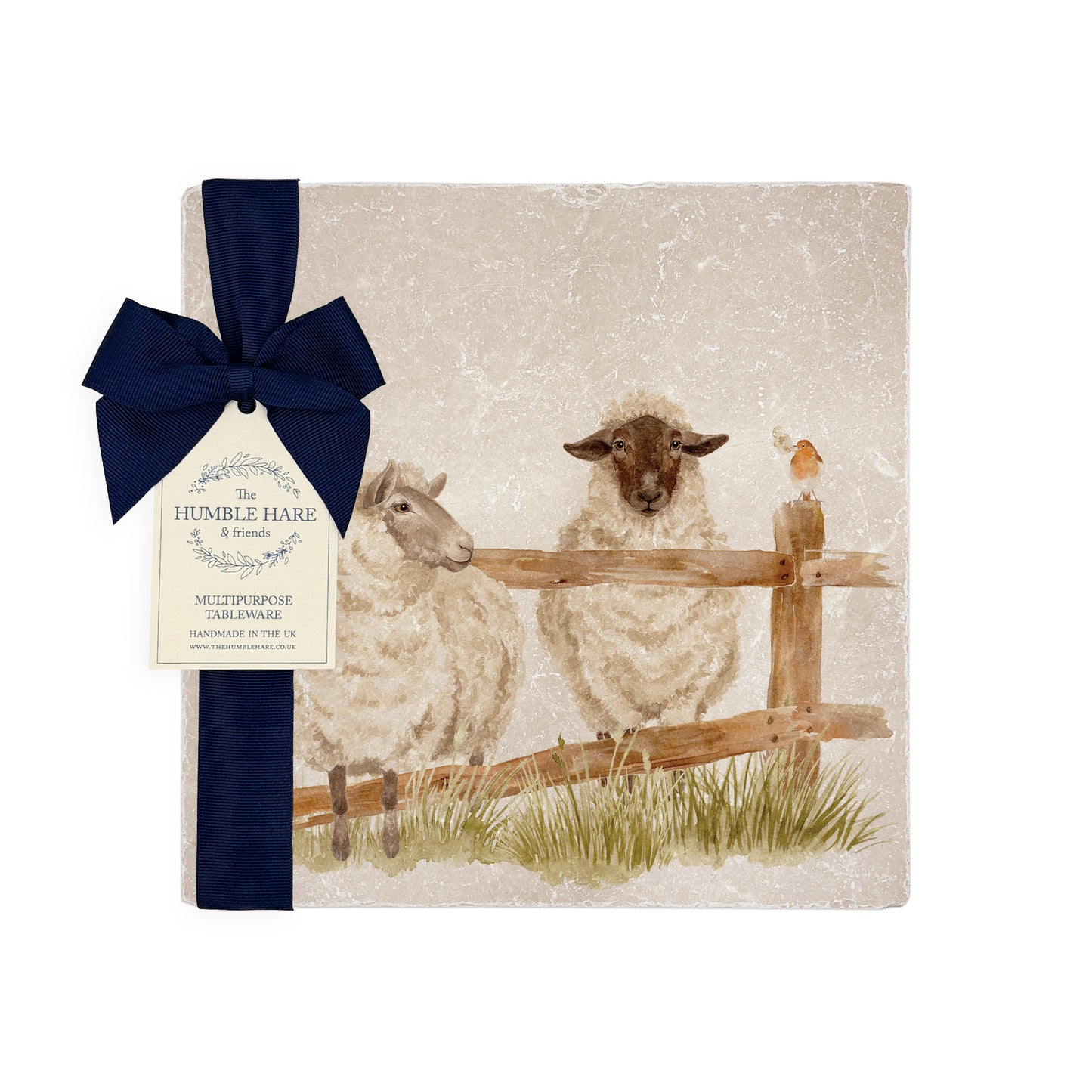 A medium multipurpose marble platter with a watercolour design of sheep escaping through a fence, packaged with a luxurious dark blue bow and branded gift tag.