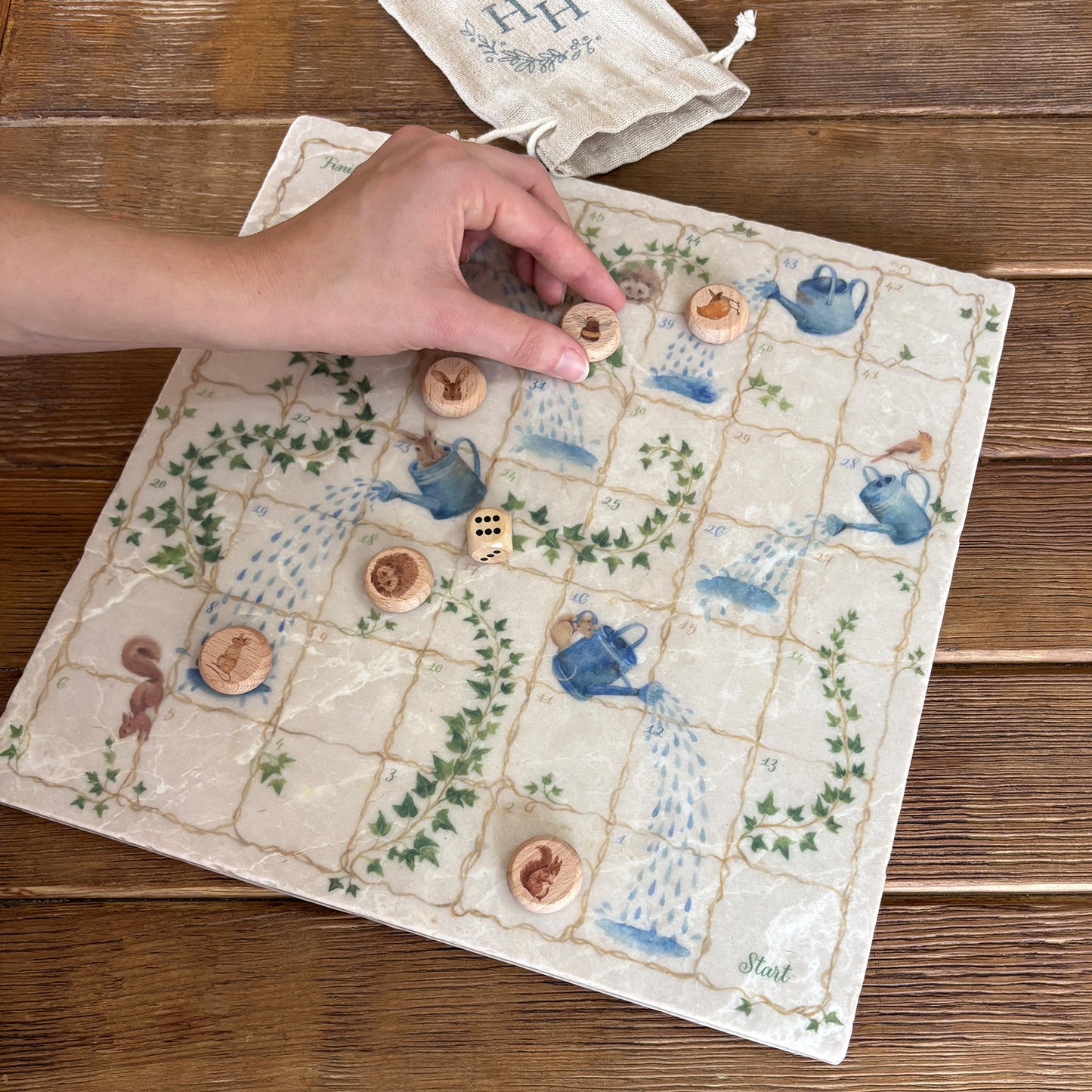 Luxury Snakes and Ladders board game handcrafted from natural marble stone, showcasing intricate detailing and timeless craftsmanship. Elegant handmade marble snakes and ladders game that doubles as a decorative o statement piece or table protector with beautiful Echo friendly packaging. This unique game features hares a squirrel Hedgehog, Bee, Robin and a mouse. these stunning illustrations are of the countryside that inspires us.