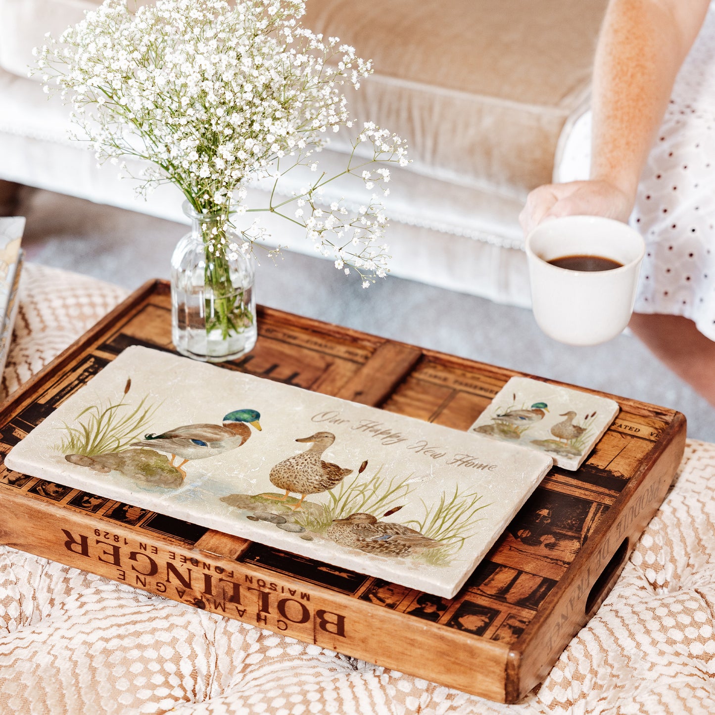 A personalised marble platter set on a coffee table, the bespoke text reads 'Our Happy New Home'.