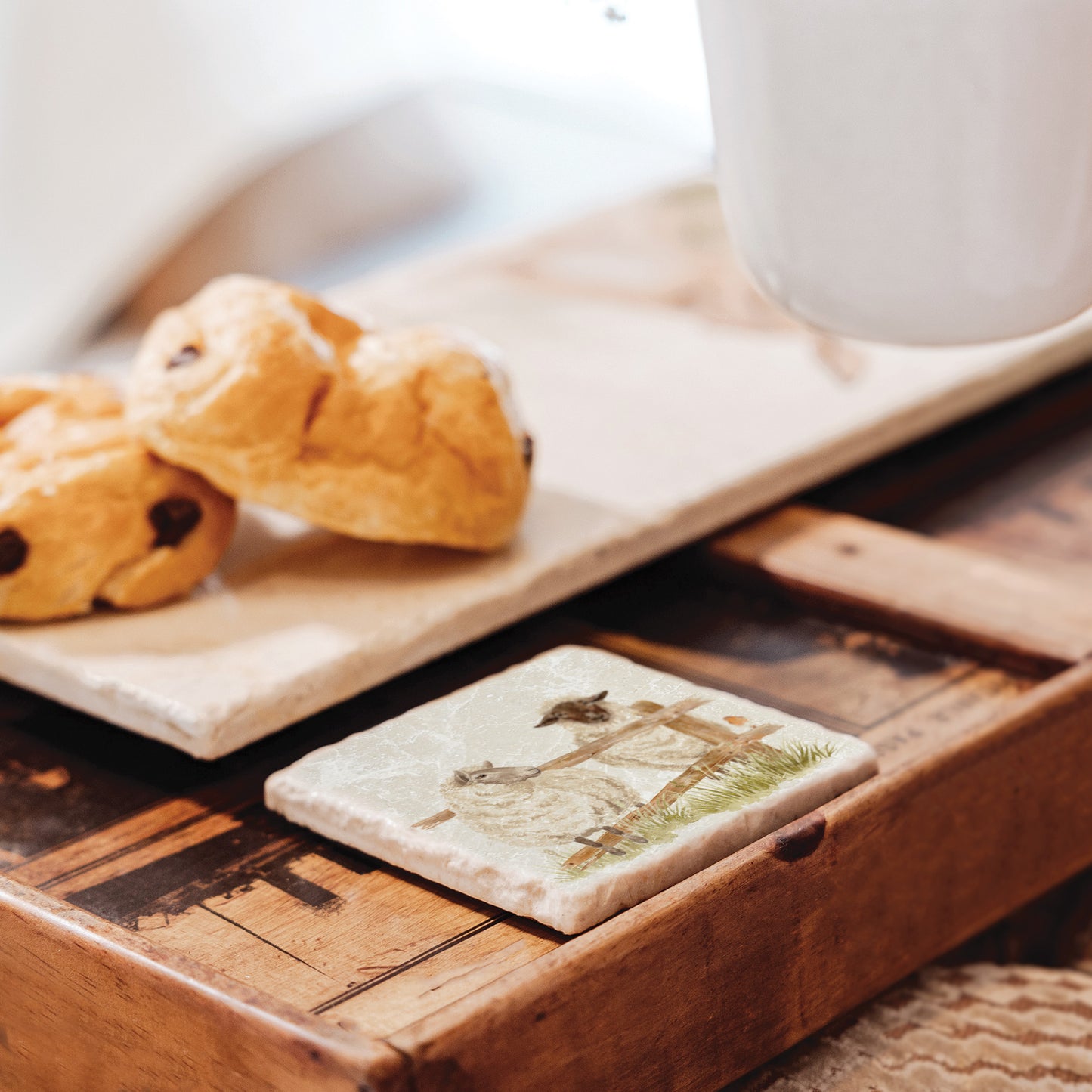 A handmade marble coaster featuring a watercolour design of two sheep escaping their field.