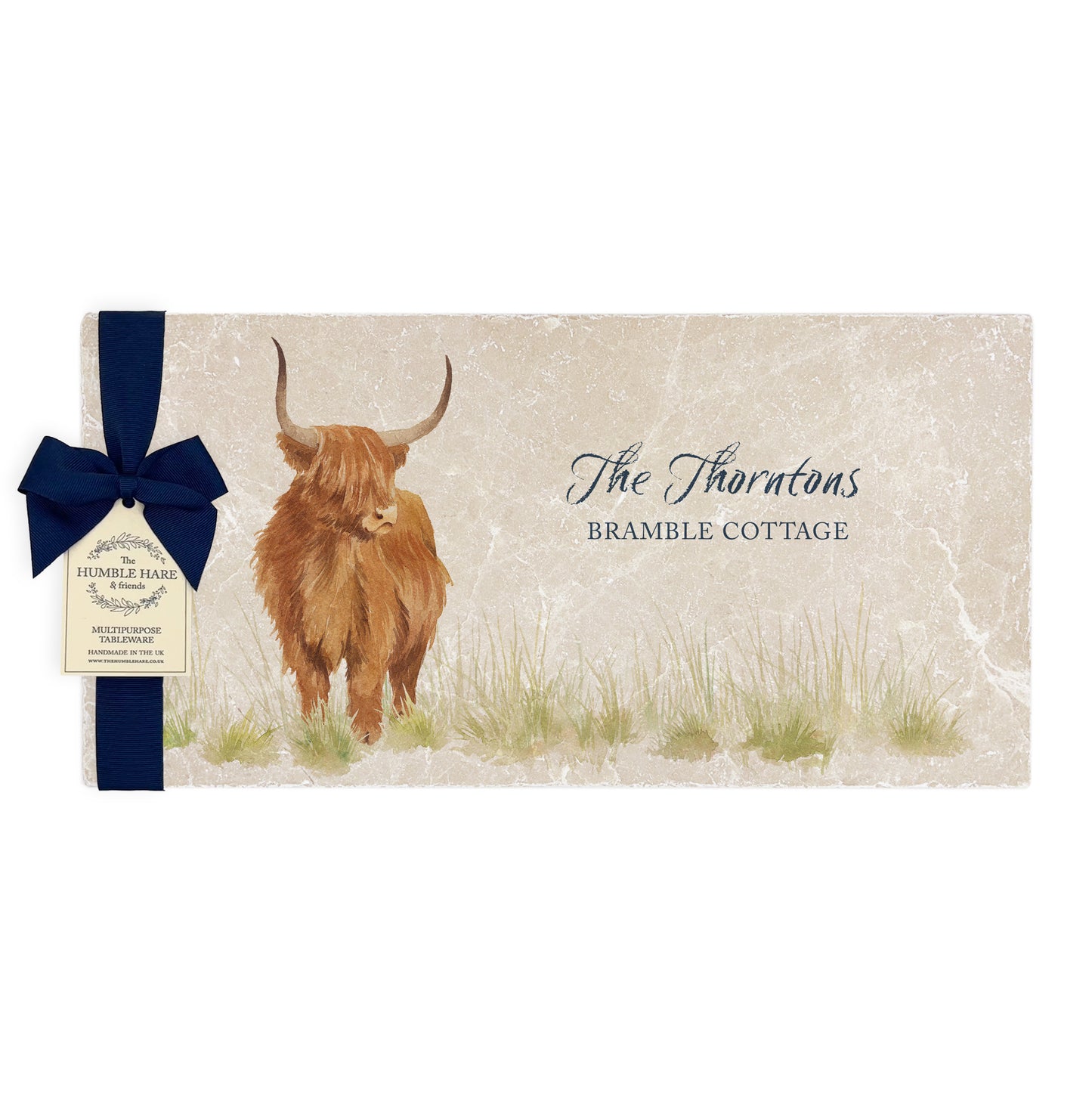 A personalised marble sharing platter featuring a highland cow in a watercolour style, packaged with a luxurious dark blue bow and branded gift tag.