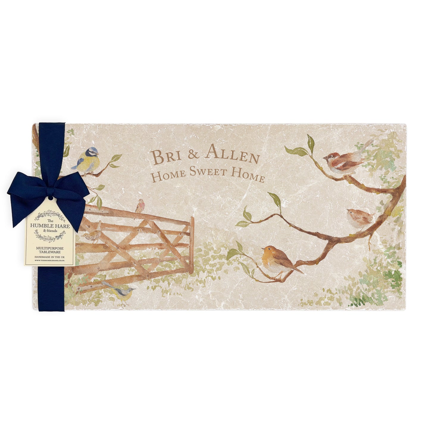 A personalised marble sharing platter featuring garden birds in the hedgerow around a paddock gate in a watercolour style, packaged with a luxurious dark blue bow and branded gift tag.