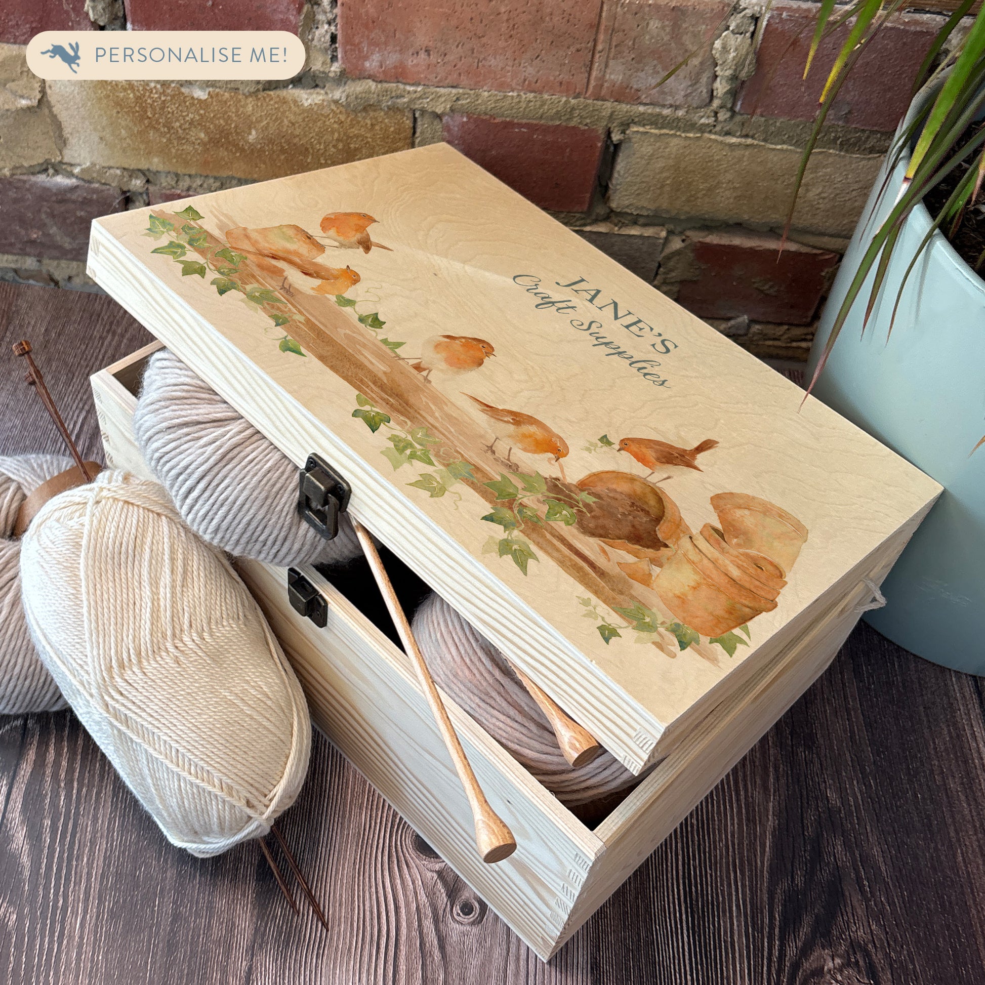 Large wooden pine gift box, The perfect Personalised keepsake, memory box, storage box with a rabble of robins playing on a greenhouse shelf covered in Ivy and plant pots, some of the robins have knocked over the plant pots leaving soil on the self.  The design  features our classic gentle watercolour style. great unique storage box