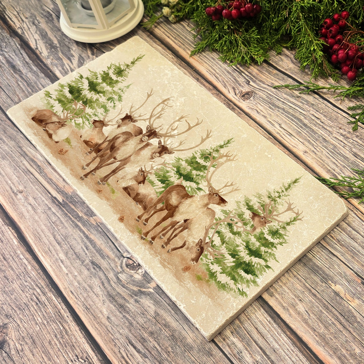 The Reindeers rest design features reindeer appearing from an opening in the wintery snowy forest.