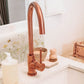 A tiled splashback behind a bathroom sink. The splashback is made up of large plain cream marble tiles, alternated with marble tiles featuring countryside scenes including bees in a buttercup meadow.