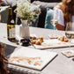 A garden table set for al fresco dining with multipurpose marble platters, including a large square marble platter featuring a fox and fox cub watercolour design.