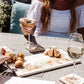 A garden table set for al fresco dining with marble platters, including a large square marble platter featuring a fox and fox cub watercolour design.