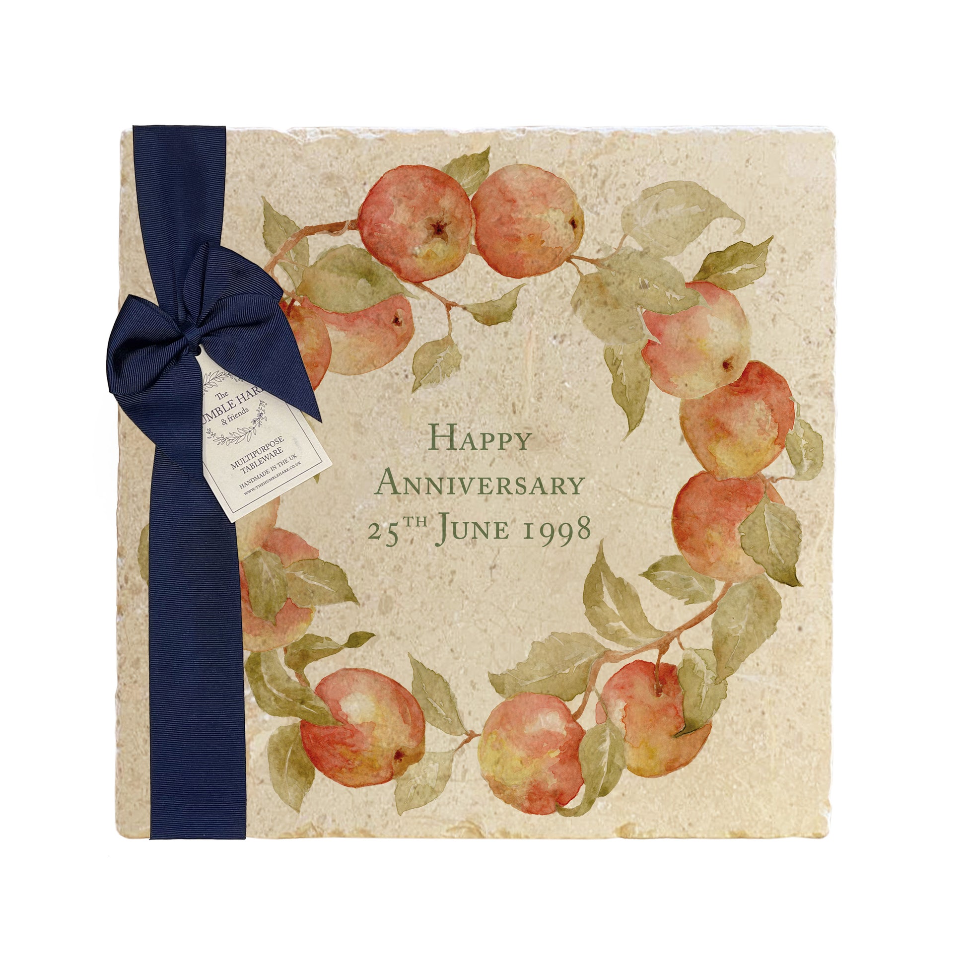 A personalised marble platter featuring a wreath of apples and leaves, with a bespoke message in the centre of the design. The platter is packaged with a luxurious blue gift bow and tag.