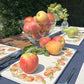 A garden table set with marble serving platters featuring an apple wreath watercolour design.