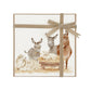 A square greeting card featuring a watercolour nativity scene with donkeys, sheep, and a baby lamb in a manger, wrapped with a champagne gold velvet ribbon and bow on a white background.