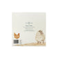 The back of a 'The Humble Hare' Christmas card featuring a watercolour illustration of a brown hen and a white sheep on a cream background, with the text 'Away in a Manger' and a barcode.