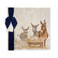 A large square marble platter featuring a rustic nativity scene illustration with three donkeys, a sheep, and a baby lamb in a wooden manger, tied with a dark navy ribbon and small paper tag on a white background.