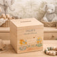 personalised handmade wooden money box styled in a cosy childrens bedroom, sweet chicks sat on speckled eggs playing with bunting with bows around their necks
