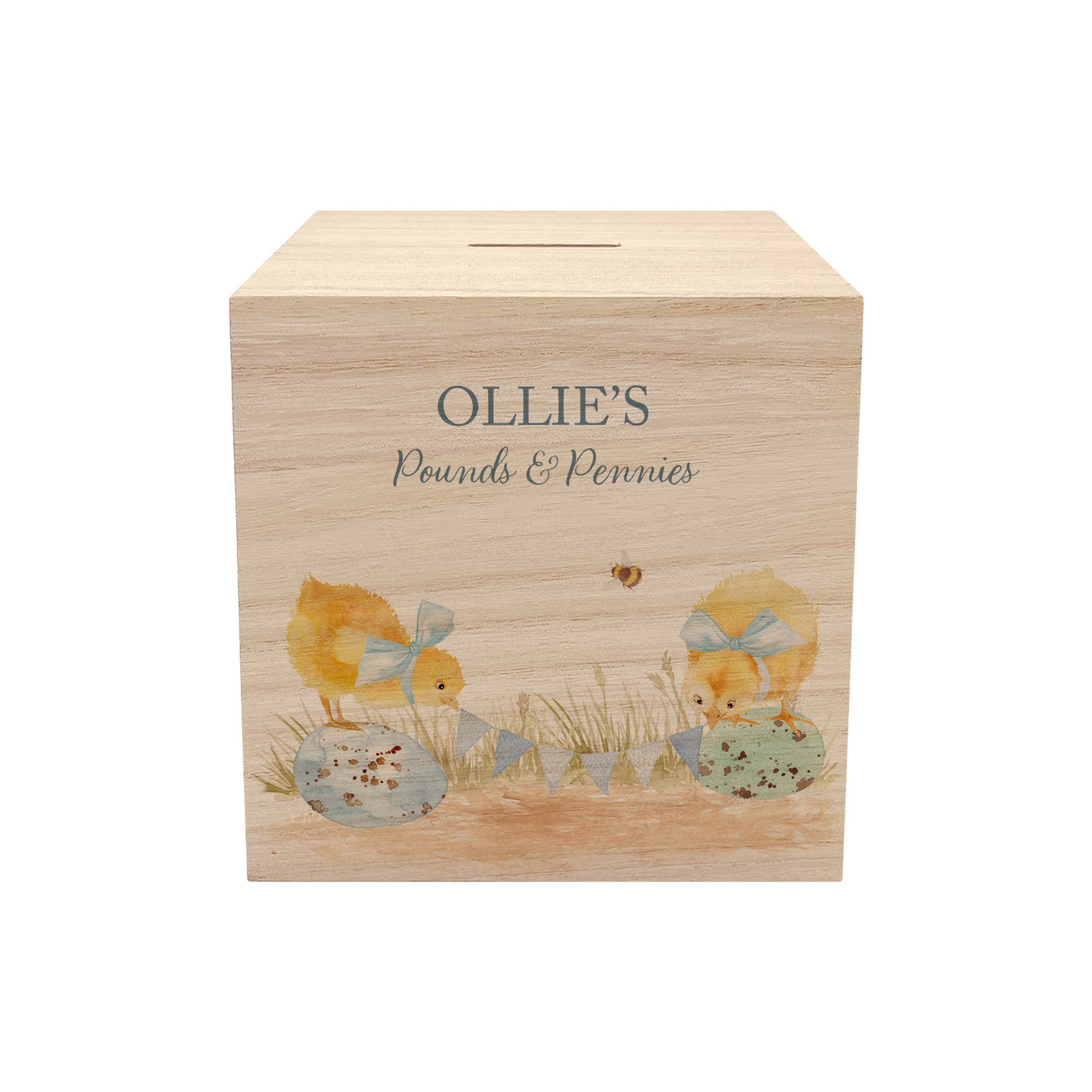 personalised handmade wooden money box styled in a cosy childrens bedroom, sweet chicks sat on speckled eggs playing with bunting with bows around their necks