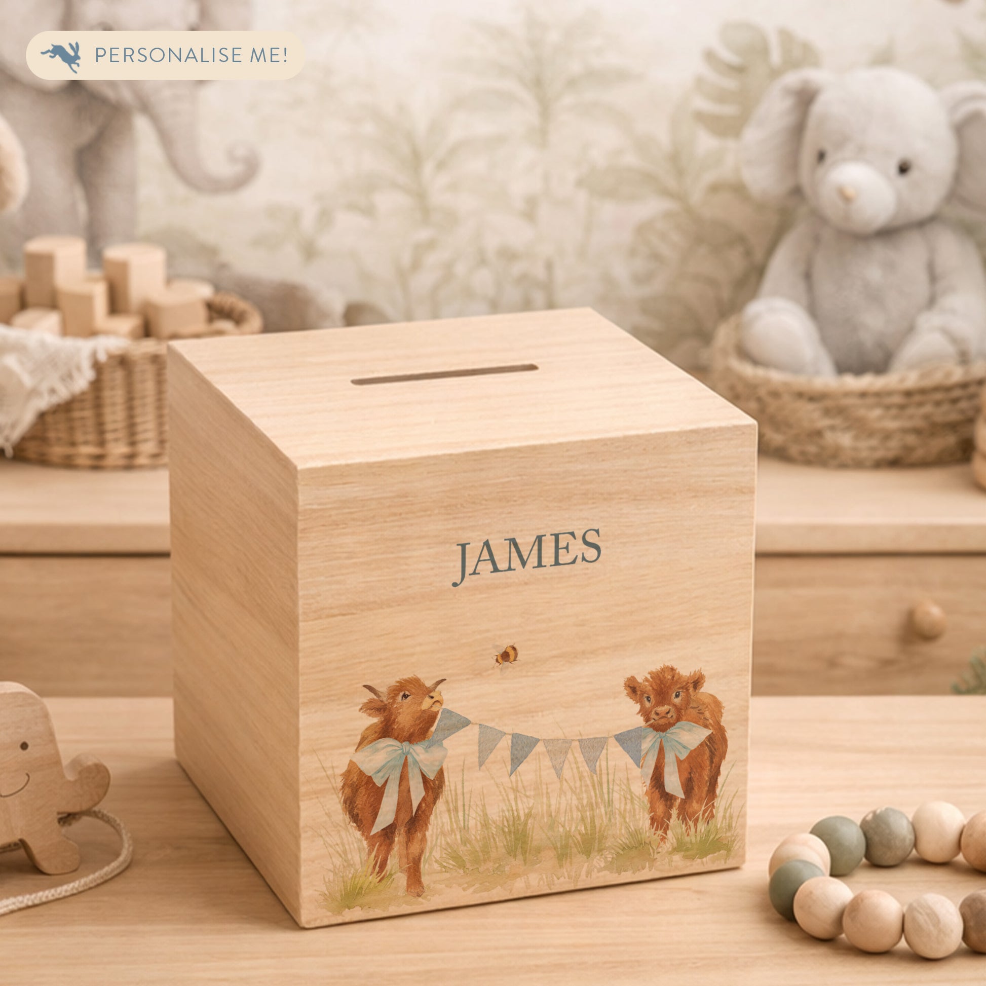 personalised watercolour money box handmade for christening keepsake, sweet highland cow babies playing in a field with bunting with bows around their necks
