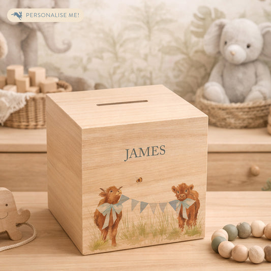 personalised watercolour money box handmade for christening keepsake, sweet highland cow babies playing in a field with bunting with bows around their necks