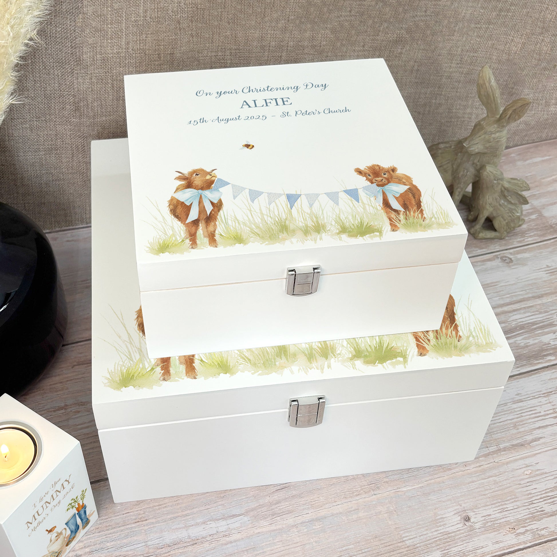 A white wooden keepsake box featuring a sweet baby highland cows design, personalised with custom text. Choose from two sizes, medium and large.