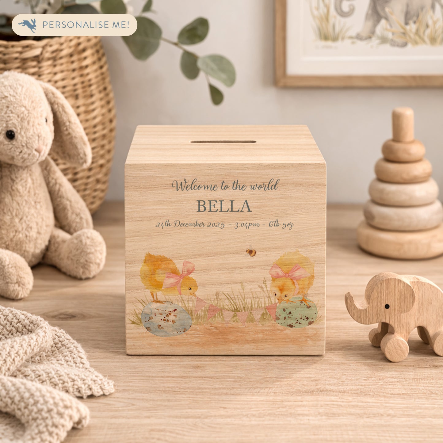 personalised handmade wooden money box styled in a cosy childrens bedroom, sweet chicks sat on speckled eggs playing with bunting with bows around their necks