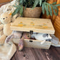 Large sized wooden pine personalised keepsake box. The design theme is perfect for New babies, Welcome to the world, baby showers and christenings. The picture also shows an example in a nursey room filled with nappies, vests and teddys. 