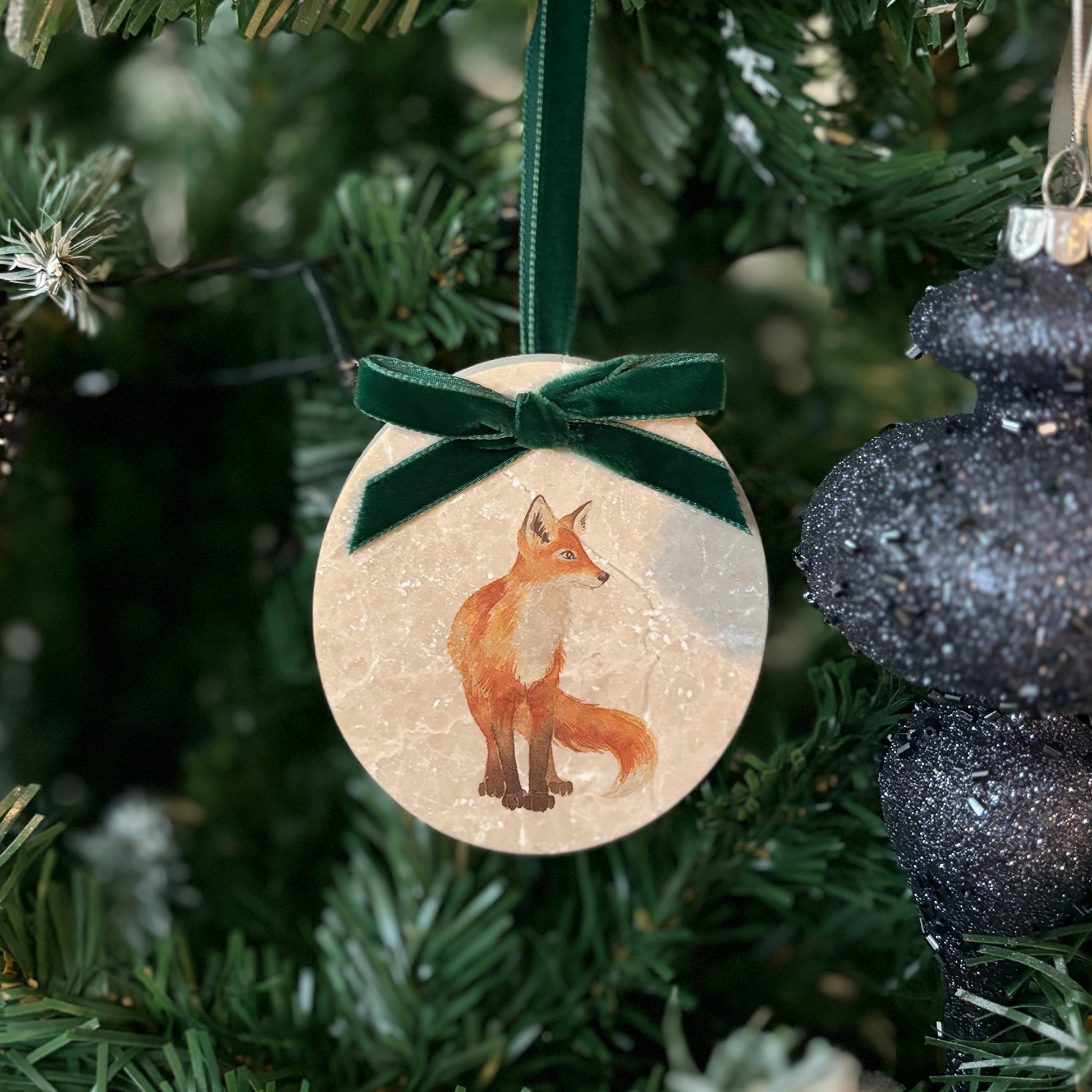 A marble bauble featuring a watercolour fox cub design, and finished with a velvet ribbon, available in your choice of colour. Personalisation is also available to create a unique, memorable keepsake.