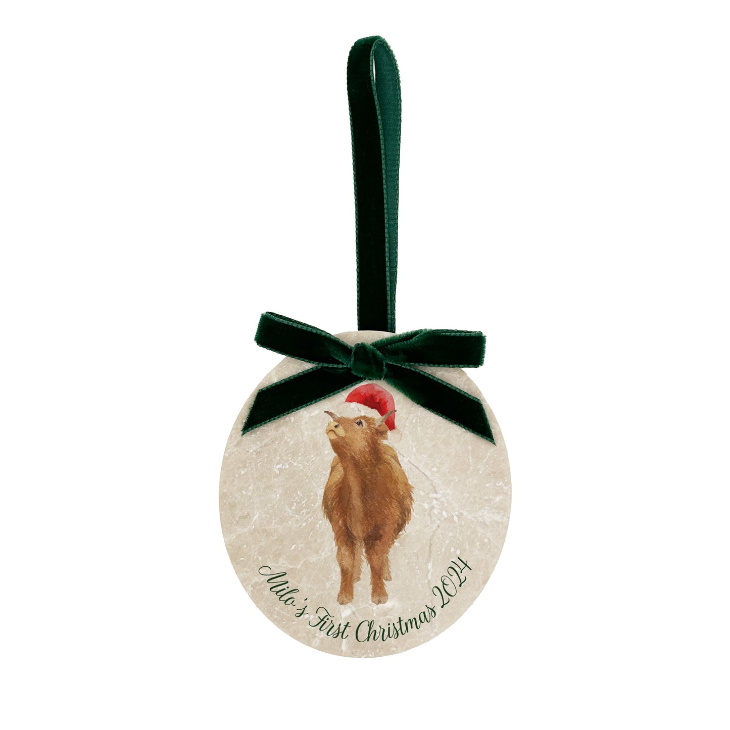 An oval marble bauble featuring a watercolour baby Highland cow, with personalised text to celebrate baby's first Christmas, and the option to add a Santa hat. The bauble is finished with a velvet ribbon.