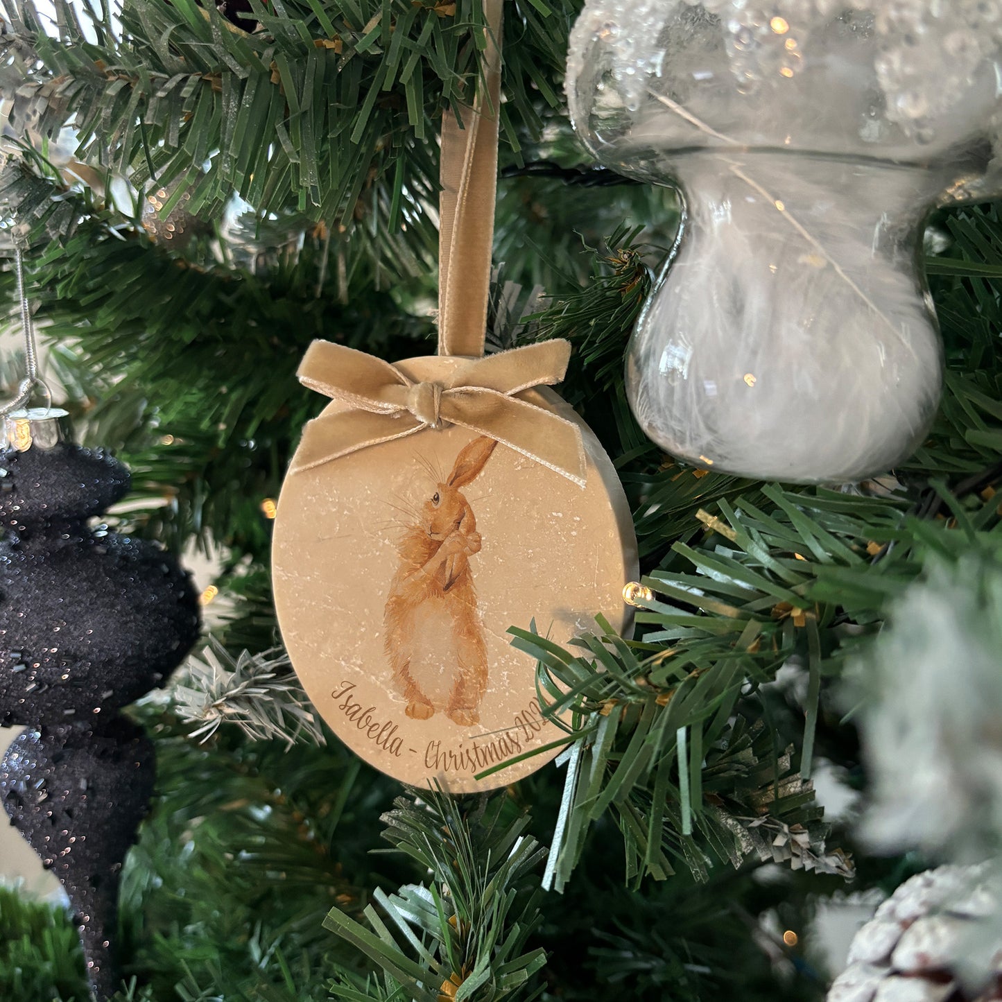 Bring the charm of the countryside into your home this holiday season with our oval-shaped marble baubles. Featuring a watercolour hare and finished with a velvet ribbon, personalise your bauble to add a bespoke touch to your Christmas decorations.