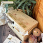 Large sized wooden pine personalised keepsake box. The design theme is perfect for New babies, Welcome to the world, baby showers and christenings. This design has baby lambs  in playing in grass with a little bee flying around.  The picture also shows an example in a nursey room filled with nappies, vests and teddys. 