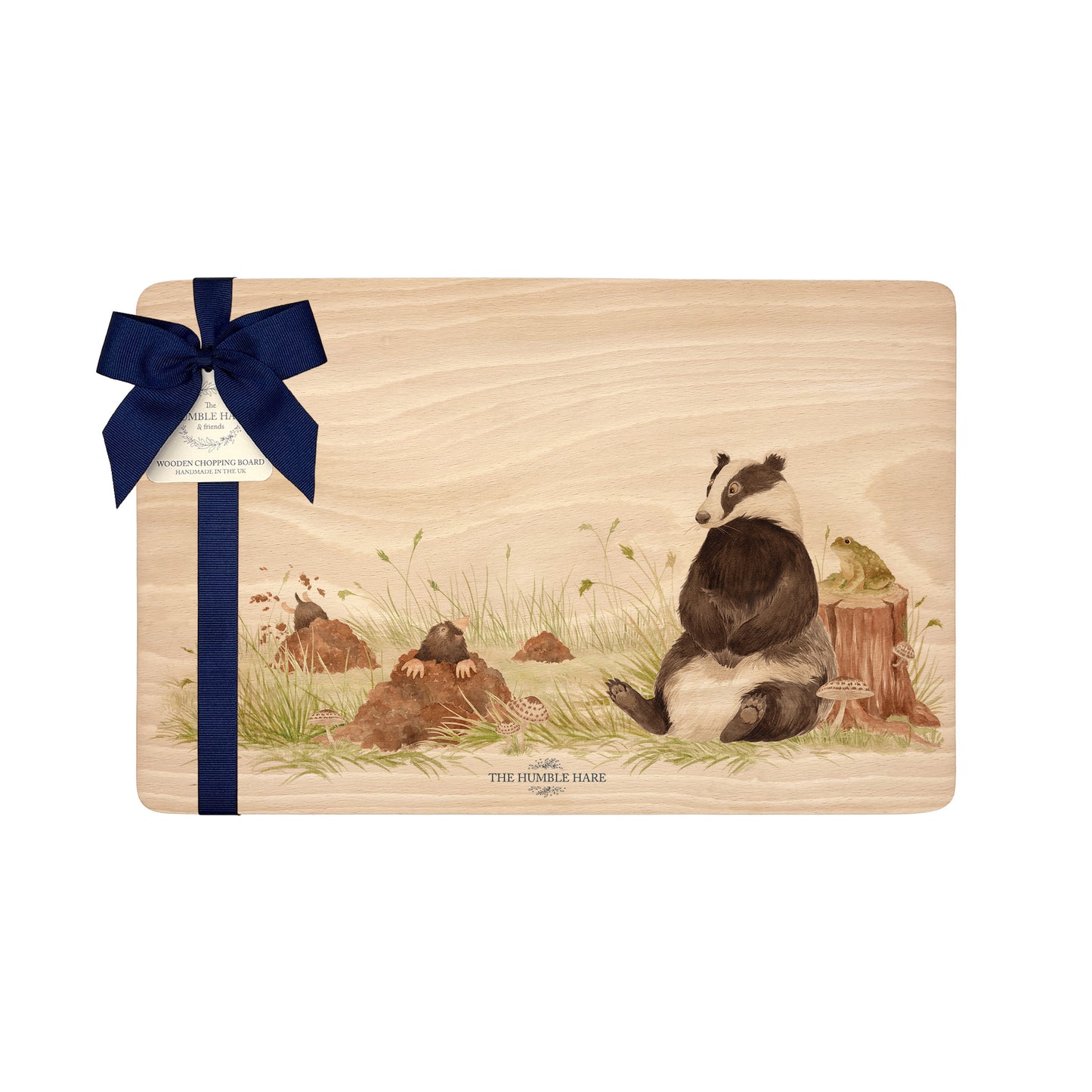 Rectangle beech wood chopping board featuring a watercolour design of a badger, mole and toad in the woodland. The wooden board is finished with a blue gift ribbon and tag.